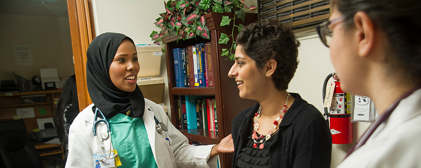Medical students Ifrah Ali, left, and Talin Arslanian, right, chat with a chats with an undergraduate volunteer, Simirin Atwal, during their shift at the Shifa Community Clinic in downtown Sacramento. (Karin Higgins/UC Davis)
