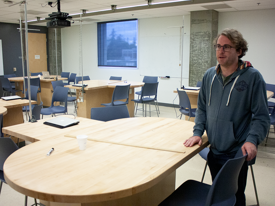 Christopher Brainerd, physics and astronomy instructional support unit manager, stands beside new work surfaces in a physics classroom.