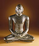 Image of a buddah like figure of cast metal, sitting cross legged