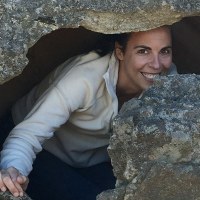 UC Davis anthropologist peeking out from behind cave walls