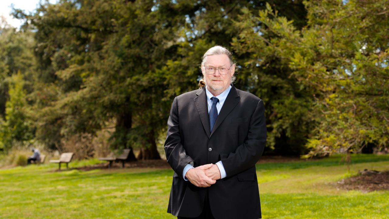 David Britt, UC Davis professor of chemistry, stands on a grass lawn