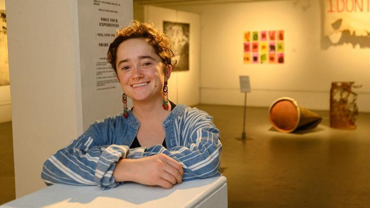 Photo of UC Davis student, smiling, inside a campus art museum.