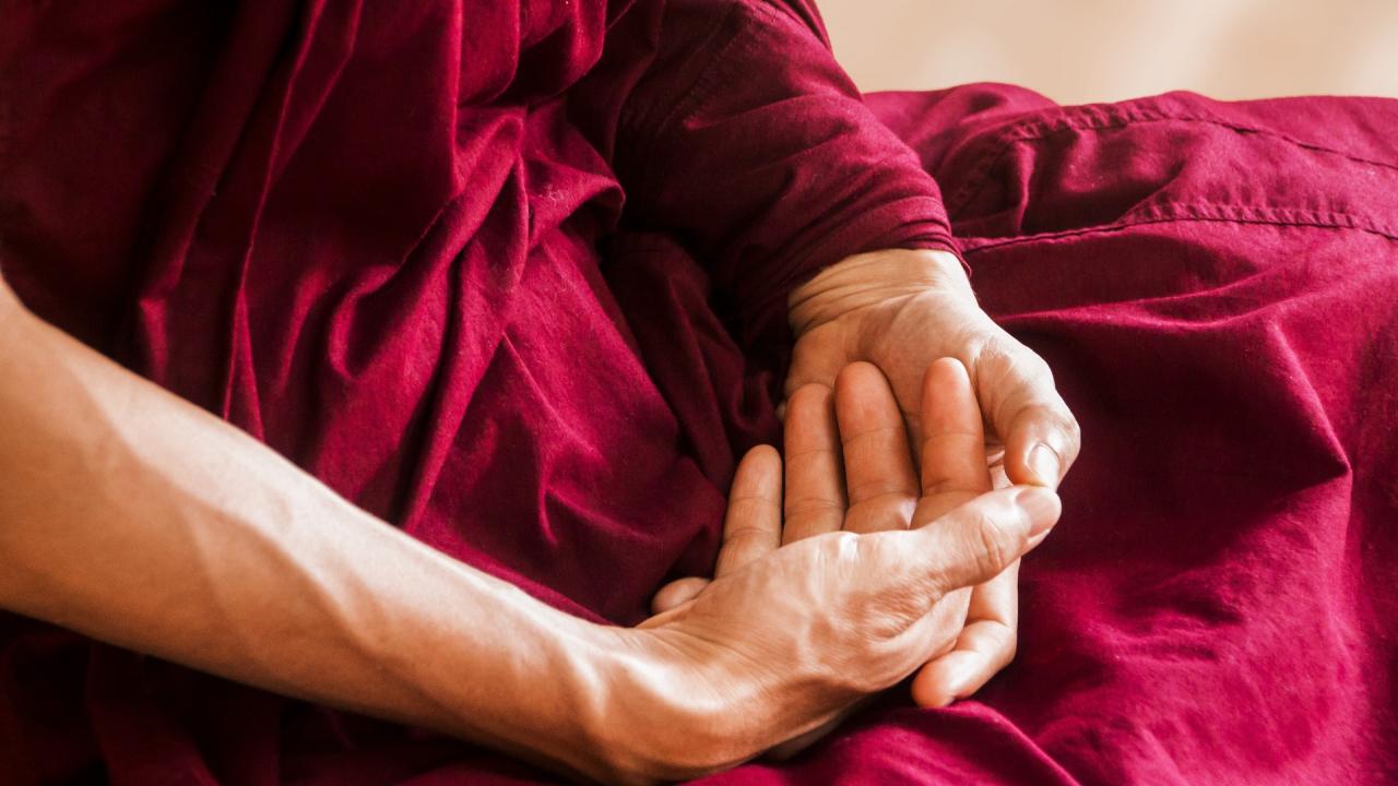 Photo of folded hands of meditating monk
