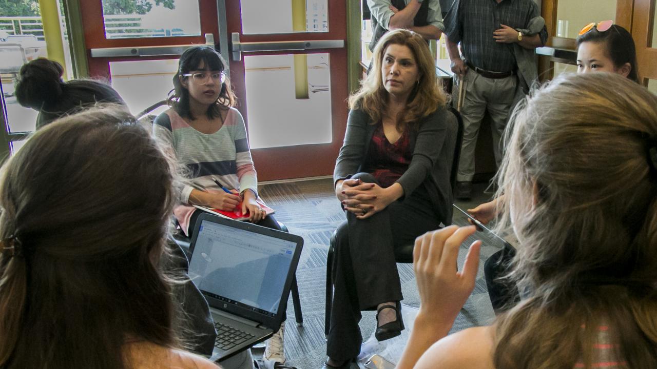 Photo of professor and students talking in a circle