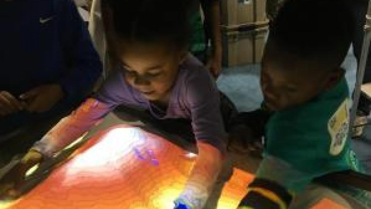 Children play with the UC Davis AR Sandbox