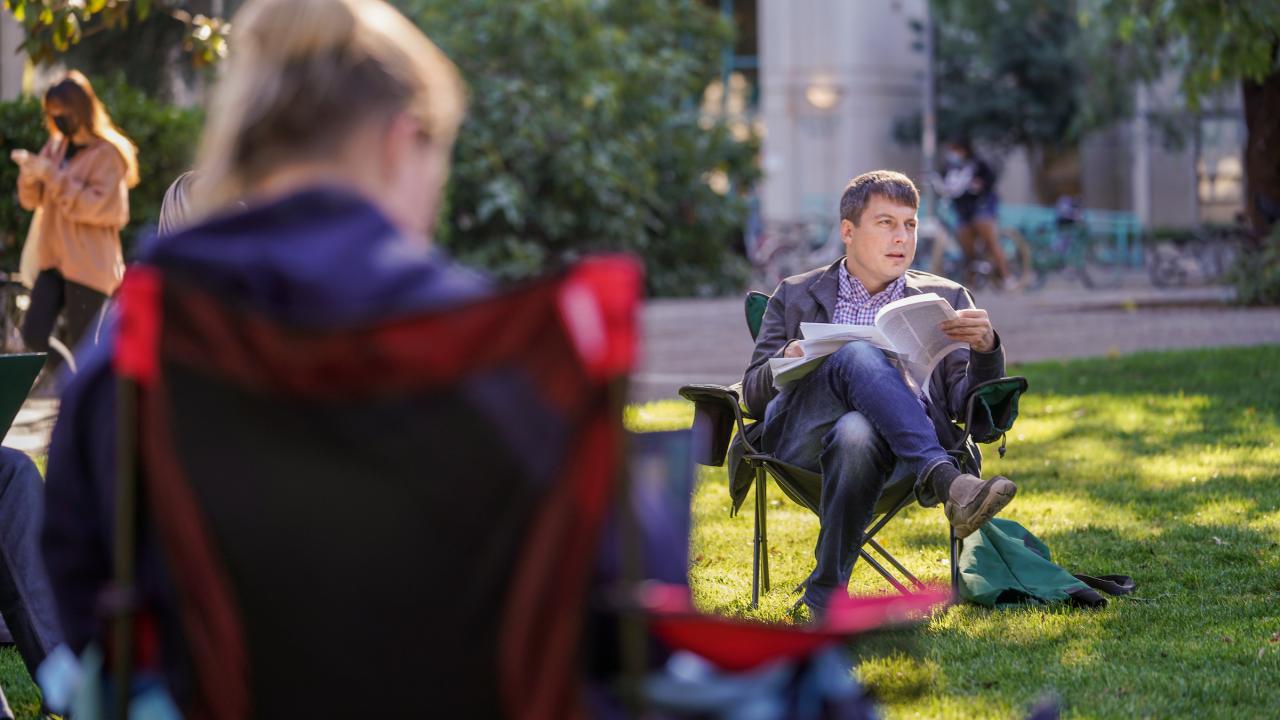 Looking over the shoulder of a student at a professor in an outdoor class at UC Davis