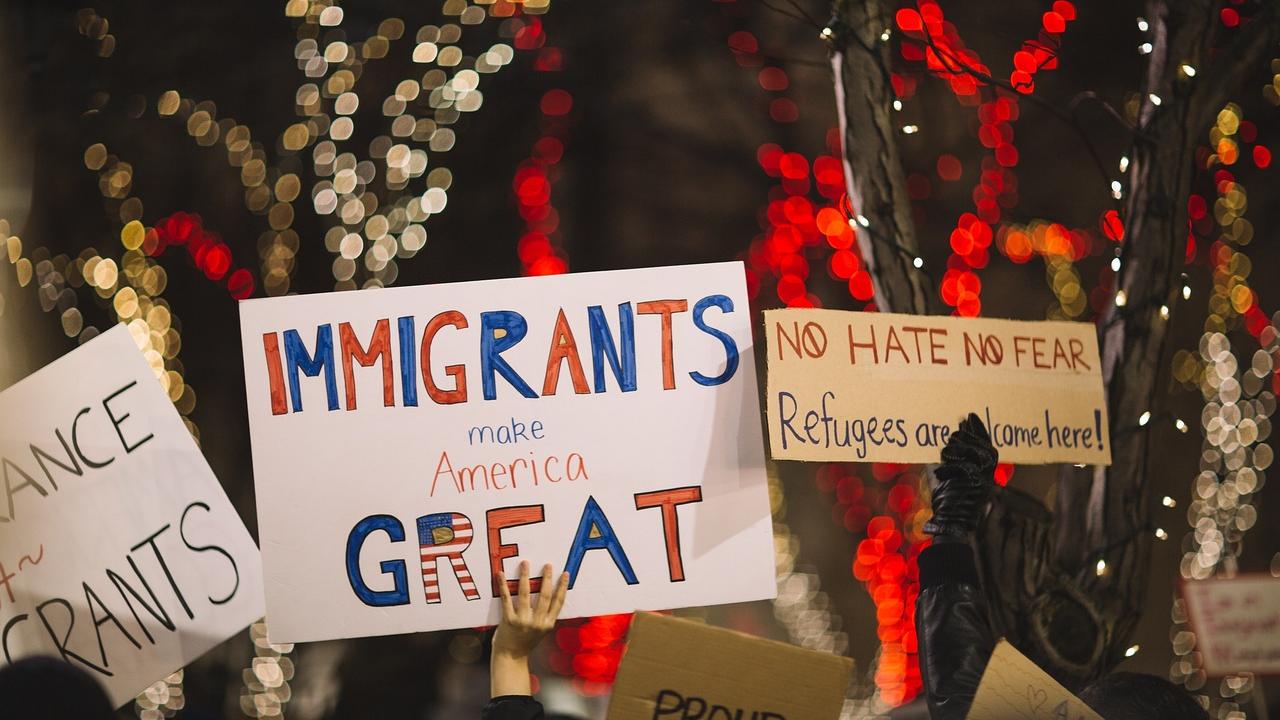 A view of posters with the one in the center reading, 'Immigrants make America great.'