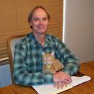 Portrait photo of UC Davis political science alum and author Tom Garrison with cat