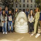A group of students stand next to an Egghead sculpture