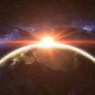sun beams flare behind planet Earth